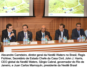 Bancada com homens de terno e gravata lado a lado. Em frente a cada um há um microfone e garrafas de água.